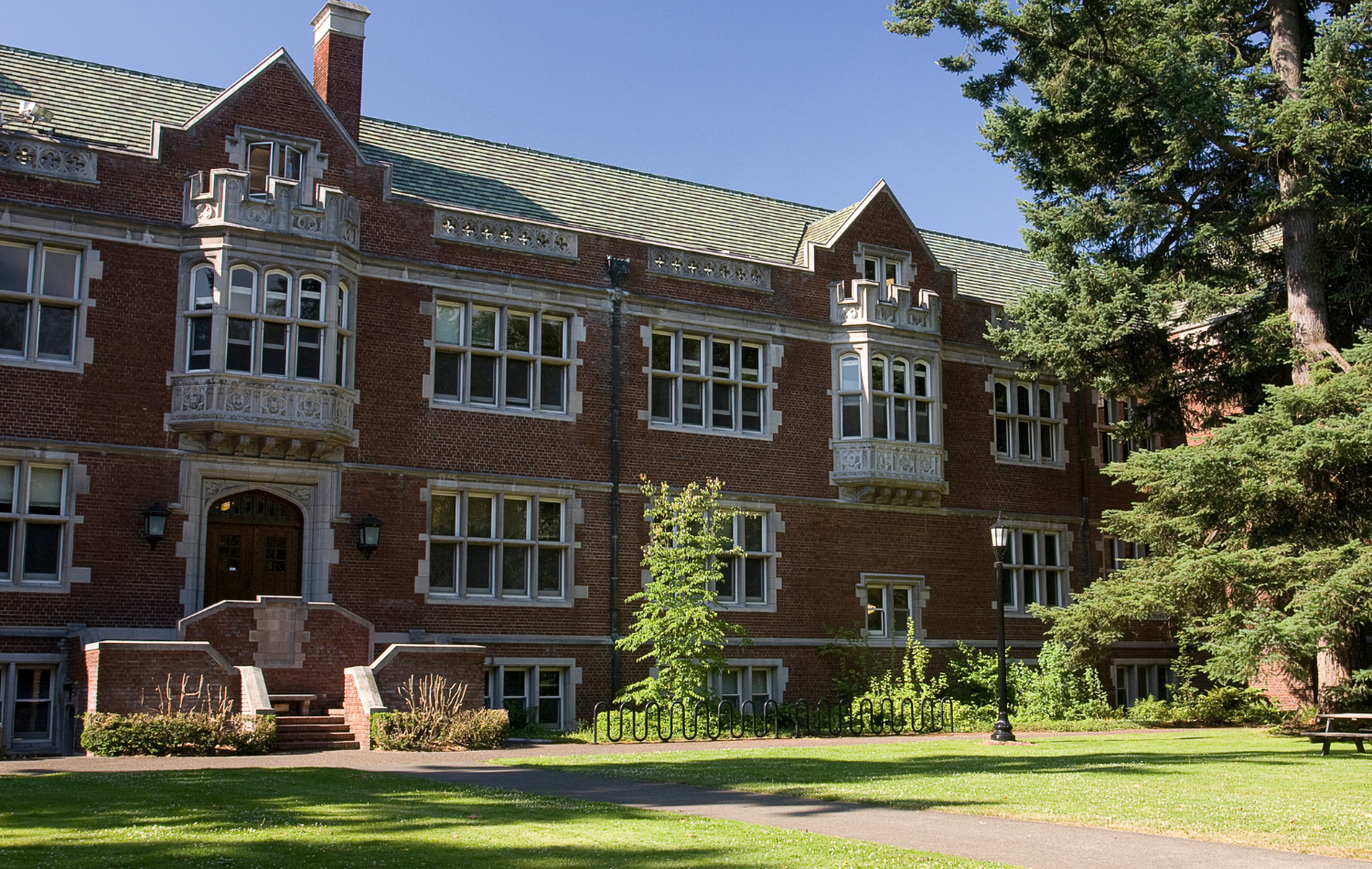 Historic red brick university academic building on a green campus quad
